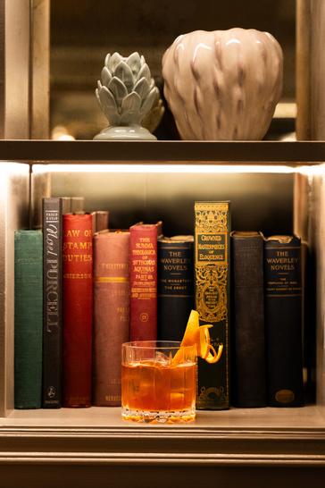 Brooks Hotel | D02 TV06 | Cocktail sitting on bookshelf with books behind